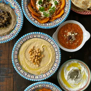 A mezze platter of hummus, falafel, pastries and salad.